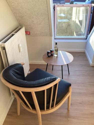 a chair and a table in a room at Lækker ny lejlighed med eget Badeværelse in Hirtshals