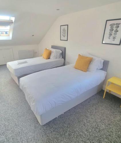 two white beds in a room with a table at London En-suite Double Rooms - Leytonstone E11 in London