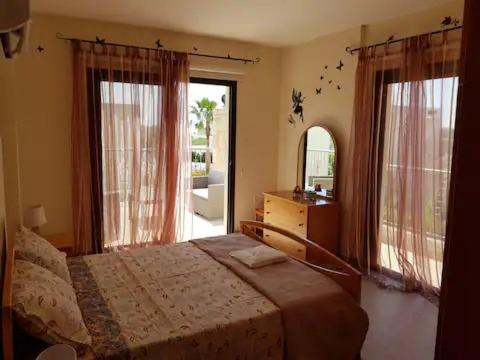a bedroom with a bed and a large window at Luxury 4 bed villa Paphos in Mesogi