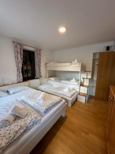 a bedroom with three beds and a window at Apartment Hribovc with atrium and free parking in Kranjska Gora