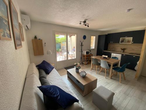 un salon avec un canapé et une table dans l'établissement Charmante maison à Le Barcarès, au Barcarès