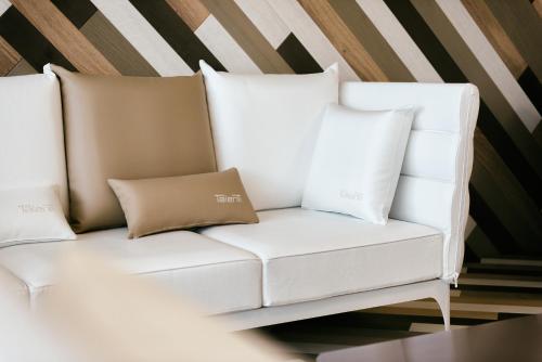 a white couch with two pillows on it at Laguna Park Hotel 4Superior in Bibione