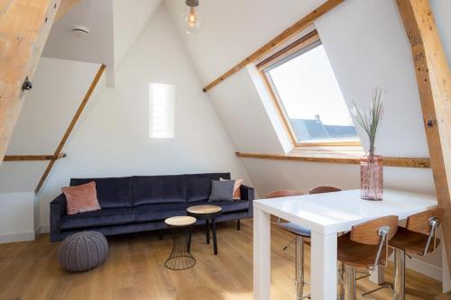 a living room with a blue couch and a table at Eindhoven City Suites Hertogstraat D Modern 2P in Eindhoven