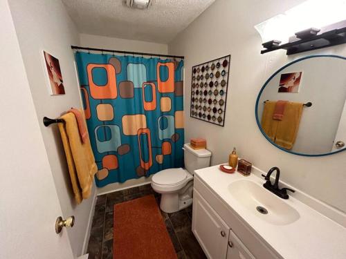a bathroom with a sink and a toilet and a mirror at Hot Tub Time Capsule with Waterbed & Jukebox in Middle Grove