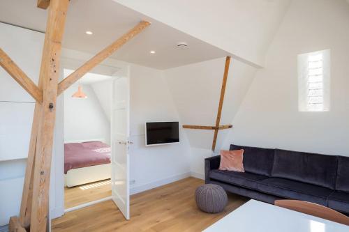a living room with a couch and a bed at Eindhoven City Suites Hertogstraat D Modern 2P in Eindhoven