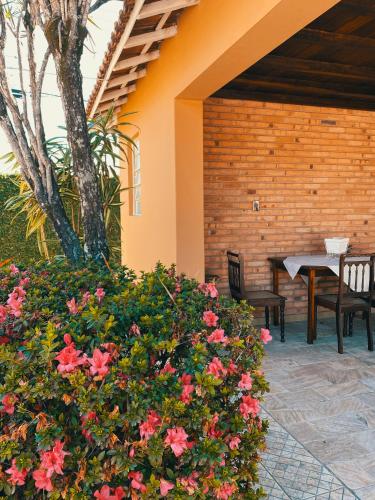 a patio with a table and chairs and flowers at O Paturi - Village Hotel Proximo Aparecida in Guaratinguetá