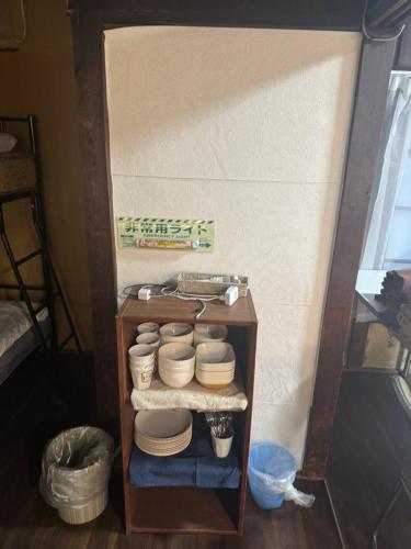 a shelf filled with bowls and plates in a room at Hikari Kitaayase - 光莉 北綾瀬 - 浅草や上野へアクセス良好 MAX11名の和風宿 無料Wi-Fi in Tokyo