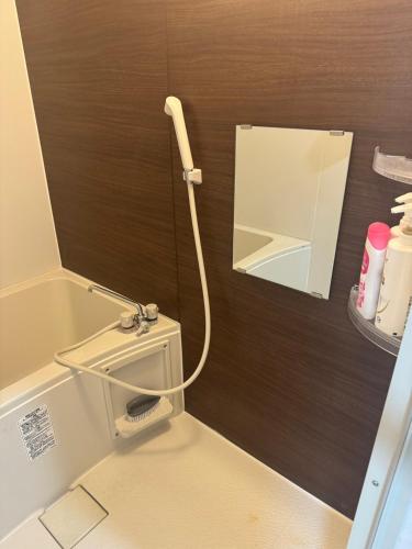 a bathroom with a toilet with a hose on the wall at Hikari Kitaayase - 光莉 北綾瀬 - 浅草や上野へアクセス良好 MAX11名の和風宿 無料Wi-Fi in Tokyo