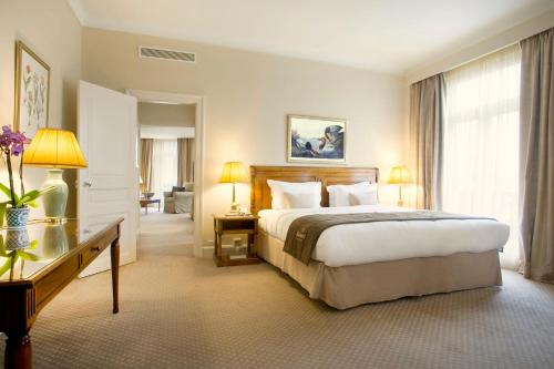 a hotel room with a large bed and a desk at Hotel Le Plaza Brussels in Brussels