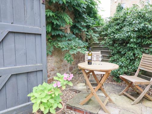 a table with a bottle of wine sitting next to a chair at The Stone Barn in Loders