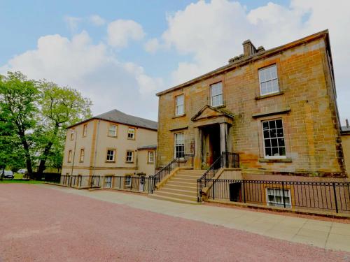 an old brick building with stairs in front of it at Knightsridge House in Livingston