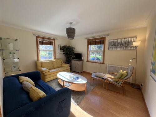 a living room with a blue couch and a table at Knightsridge House in Livingston