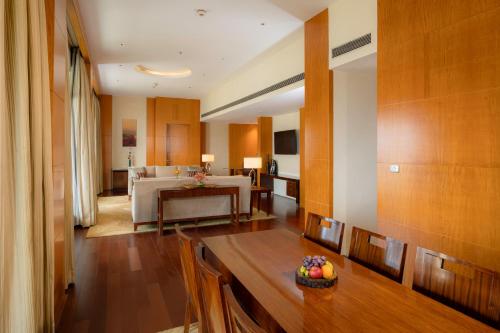 a living room with a table and a dining room at Hyatt Regency Pune Hotel & Residences in Pune