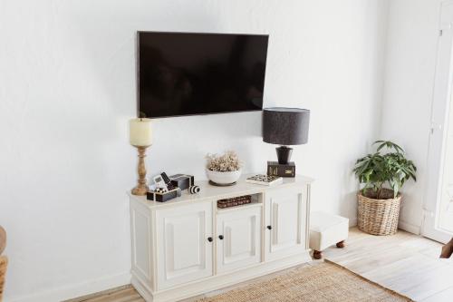 a living room with a white tv on a wall at Casa Vó Briata in Mértola
