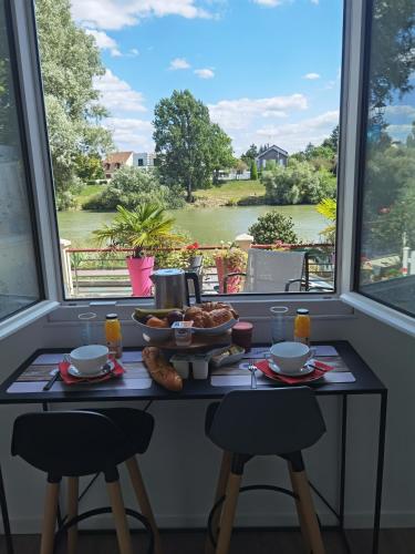 - une table de petit-déjeuner avec vue sur la rivière dans l'établissement Les Pingouins de la Marne 2, à Le Perreux-Sur-Marne