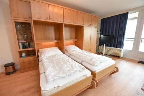 a bedroom with two beds and a tv in it at Haus "Panorama" Appartement PAN056 in Duhnen