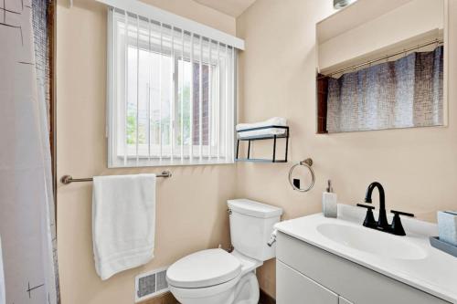 a bathroom with a toilet and a sink and a window at Stylish Comfy Shleby Retreat Patio Parking in Shelby