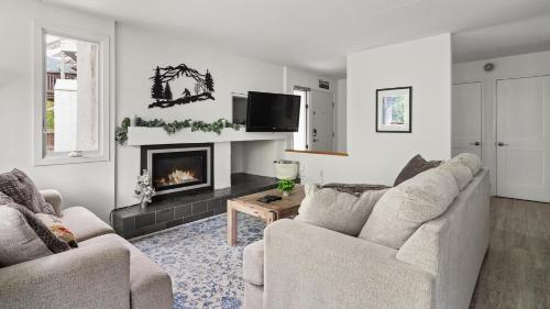 a living room with two chairs and a fireplace at Bridges Circle condo in Warren