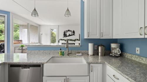 a kitchen with white cabinets and a sink at Bridges Circle condo in Warren