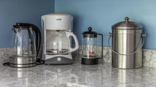 a counter with three blenders and a blender on it at Bridges Circle condo in Warren
