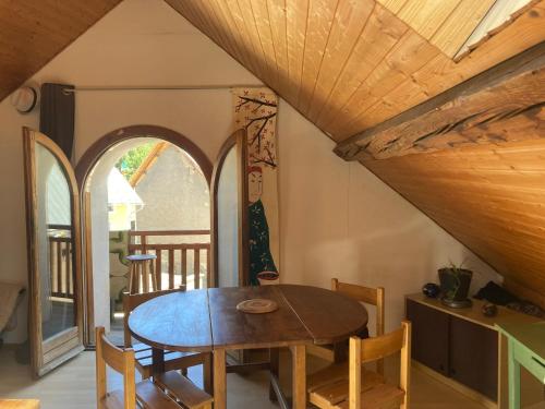 a dining room with a wooden table and chairs at flat-sharing Colocation in Briançon
