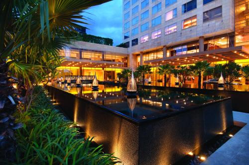 a hotel with a pool in front of a building at Hyatt Regency Pune Hotel & Residences in Pune