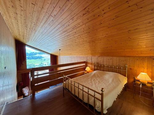 une chambre avec un lit dans une pièce en bois dans l'établissement Les Saisies - 2 pièces mezzanine pour 7 pers avec balcon sud - FR-1-293-10, aux Saisies