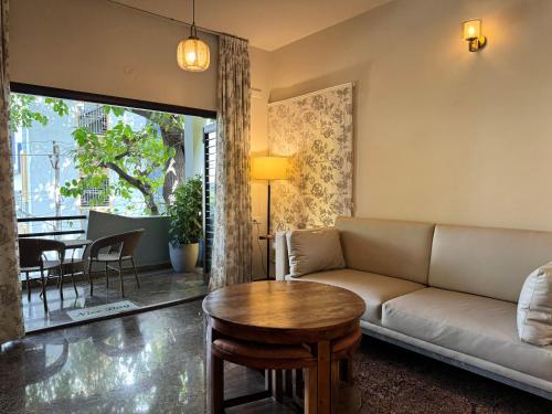 a living room with a couch and a table at Idam Na Mama - Luxury Homestay by HomeSlice in Bangalore