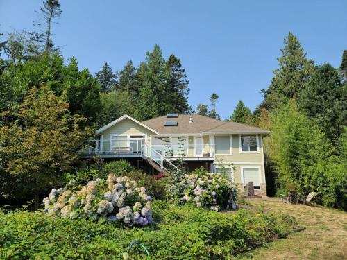 a house on a hill with bushes and flowers at Expansive Dual-Kitchen Retreat in Point Roberts