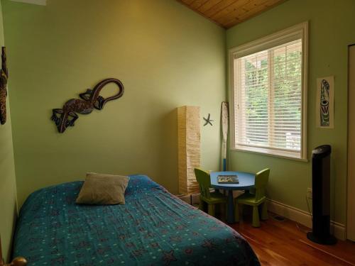 a bedroom with a bed and a table and a window at Expansive Dual-Kitchen Retreat in Point Roberts
