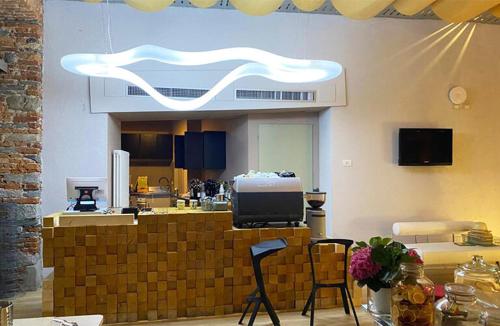 a kitchen with two chairs and a counter with a tv at Piccolo Hotel Olina in Orta San Giulio