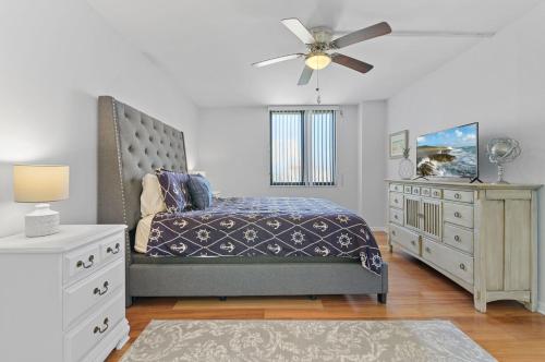 Schlafzimmer mit einem Bett, einer Kommode und einem Deckenventilator in der Unterkunft Palma Del Mar G-606 Beautiful in Point Brittany