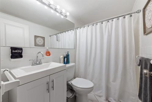 um banheiro branco com uma pia e um vaso sanitário em Downtown Studio - Panoramic Views - Walk-friendly em Atlanta