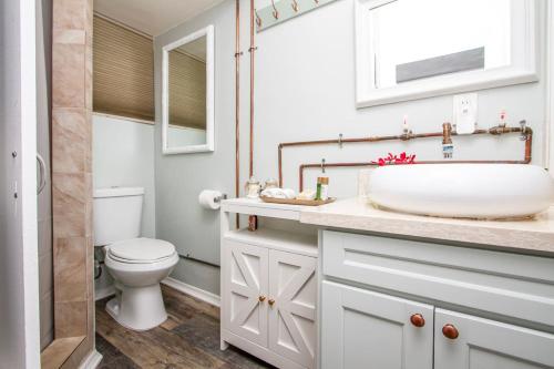 a bathroom with a white sink and a toilet at Hawaii Style Centrally located with full kitchen in Honolulu