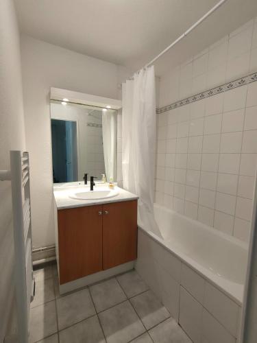 une salle de bain avec un lavabo et une baignoire dans l'établissement Appartement - Résidence Vacances calme et tout confort, à Touques