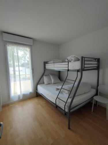 une chambre avec deux lits superposés et une fenêtre dans l'établissement Appartement - Résidence Vacances calme et tout confort, à Touques