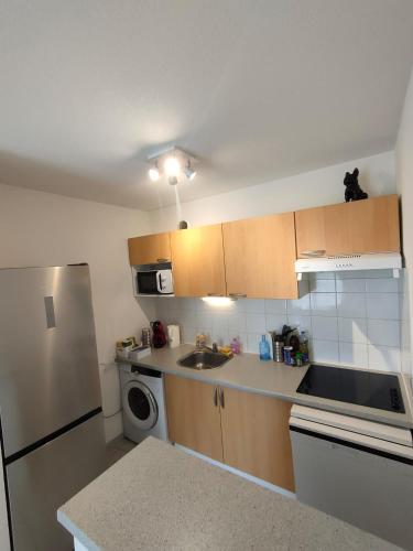 une petite cuisine avec un évier et un réfrigérateur dans l'établissement Appartement - Résidence Vacances calme et tout confort, à Touques