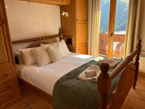 une chambre avec un lit et une grande fenêtre dans l'établissement Montagnard - 4 bedroom apartment with stunning views, à Sainte-Foy-Tarentaise