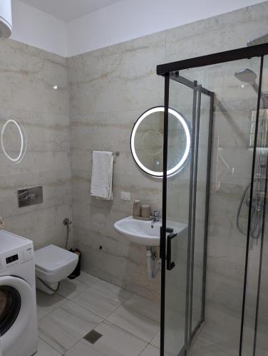 a bathroom with a sink and a washing machine at Mary's Beach Apartament Qerret in Golem