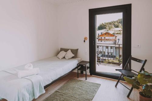 a bedroom with a bed and a large window at Cim's Apartments Cerdanya 2 in Bellver de Cerdanya