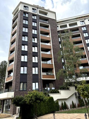 a tall apartment building with trees in front of it at Zlatibor Wayout, Spa & Wellness in Zlatibor