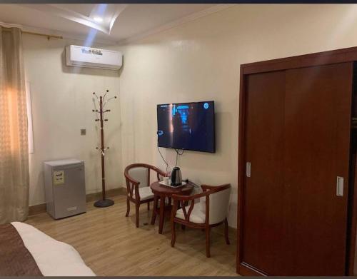 a room with a table and a tv on the wall at Fakher Yanbu Hotel in Yanbu