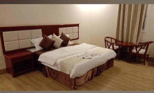 a bedroom with a bed and a desk and a chair at Fakher Yanbu Hotel in Yanbu