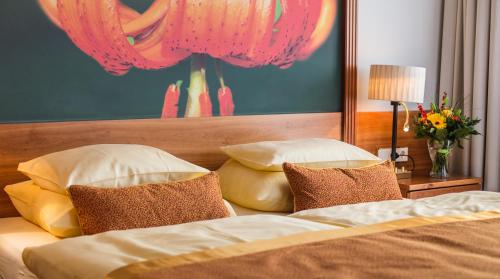 a bedroom with a bed with pillows and a painting at EUROPÄISCHER HOF Bad Gastein in Bad Gastein