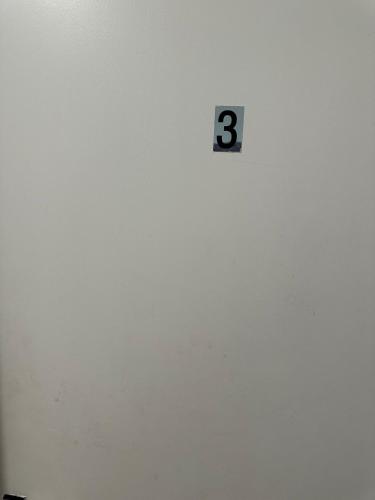 a clock on a white wall with the number three at The Great Beecholme in Streatham Vale