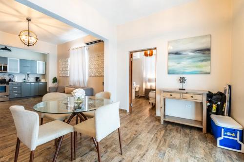 a dining room and living room with a glass table and chairs at La Mona Loiza Apartment Complex by Stay with Bear in San Juan