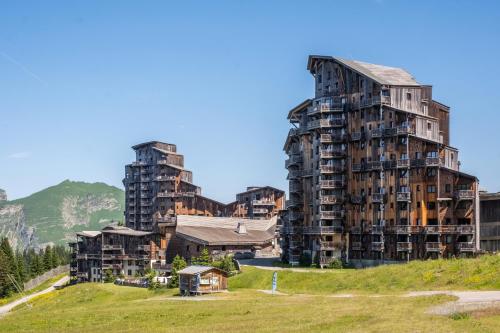 two tall buildings on top of a grassy hill at Résidence Pierre & Vacances Premium L'Amara in Avoriaz