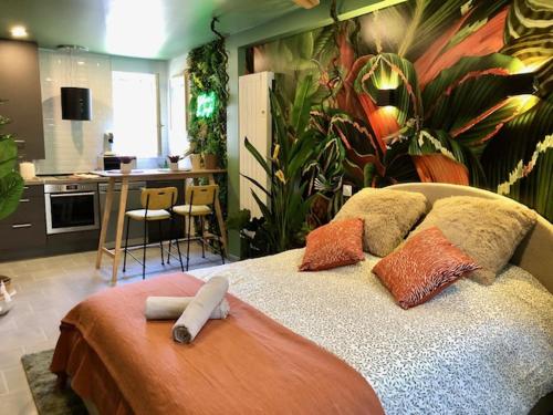 - une chambre avec un grand lit recouvert de plantes dans l'établissement Studio Jungle Climatisé, à Brive-la-Gaillarde