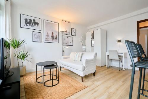 un salon avec un canapé blanc et une table dans l'établissement Appartement une chambre proche métro, à Lille