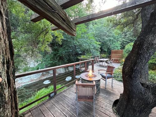 a wooden deck with a table and chairs and a tree at Either Way Hideaway in Boulder Creek